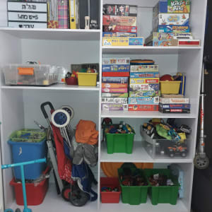 מדפים עם משחקי קופסה, קופסאות פלסטיק וקלסרים