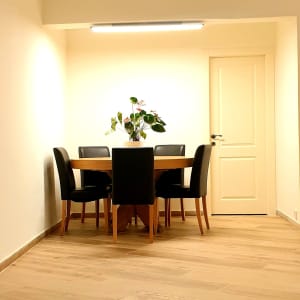 רצפת עץ חדשה בחדר מואר עם שולחן וכיסאות