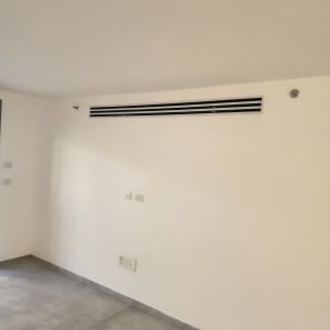 פתח מיזוג אוויר בקיר לבן