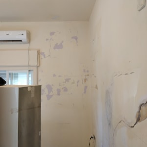 קיר עם קילופי צבע וסדקים לפני צביעה