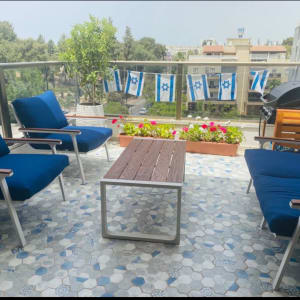 כריות כחולות על כיסאות במרפסת עם דגלים