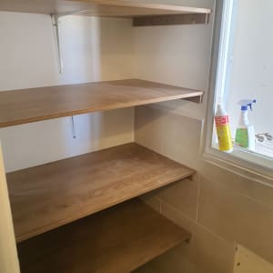 מדפי עץ מותקנים על קיר עם סוגרי מתכת