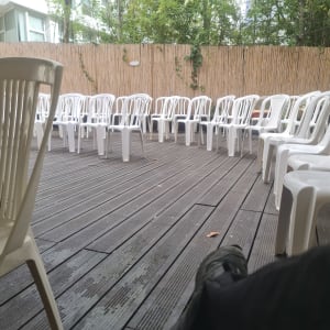 כיסאות פלסטיק לבנים מסודרים על דק עץ