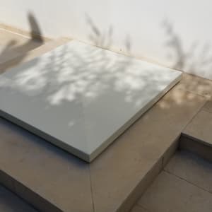 פלטת עץ מרובעת על רצפת אבן