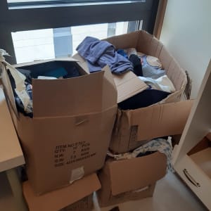 קופסאות קרטון מלאות בבגדים ליד חלון