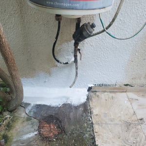 איטום קיר חיצוני עם חומר לבן סביב צינורות