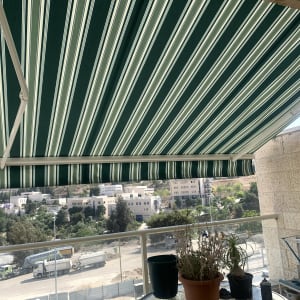 סוכך ירוק עם פסים לבנים על מרפסת