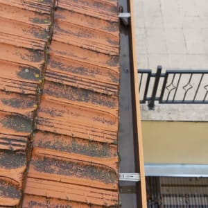 מרזב מתכת ליד גג רעפים אדום