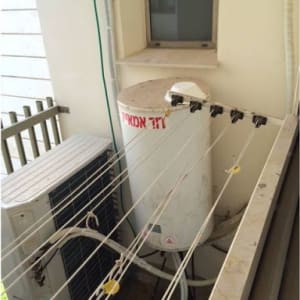 דוד שמש מותקן על מרפסת עם חוטי כביסה