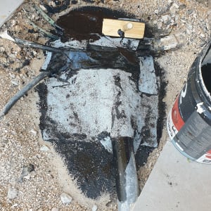 חומר איטום שחור על צינור ואזור חפירה