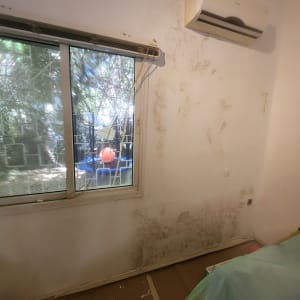 קיר עם סימני רטיבות לפני צביעה