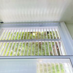 תריסי אלומיניום לבנים בחלון גדול