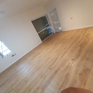 רצפה נקייה מעץ בחדר ריק עם חלונות