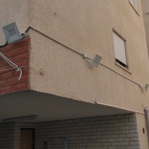 תאורת חוץ מותקנת על קיר בניין עם חיווט חשמלי