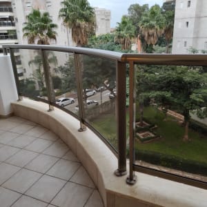 מרפסת עם רצפת אריחים ומעקה זכוכית לניקוי