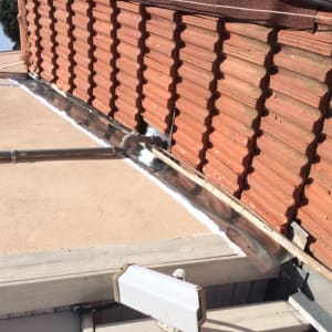 רעפים אדומים על גג עם חיפוי מתכת
