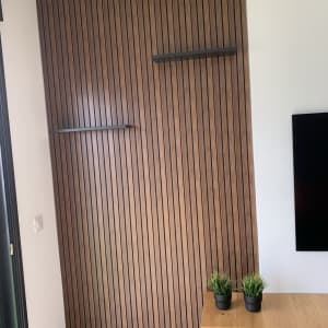 קיר עץ עם מדפים צפים ושולחן עץ