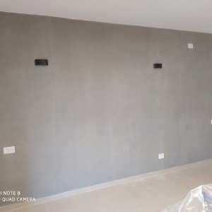 קיר צבוע בצבע אפור עם שקית ניילון על הרצפה