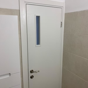 דלת לבנה עם חלון קטן וידית מתכת