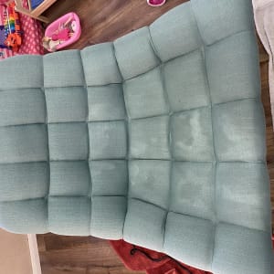 כרית ספה כחולה עם כתמים, מגבת לבנה ליד