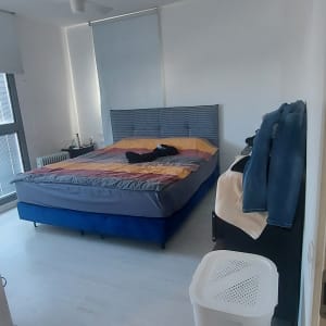 חדר שינה עם מיטה זוגית ומצעים צבעוניים