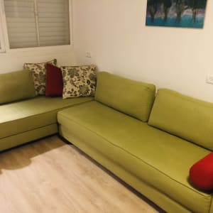 ספות ירוקות עם כריות אדומות ודוגמת פרחים