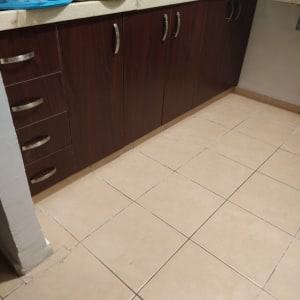 ארונות מטבח עם ידיות מתכת על רצפת קרמיקה