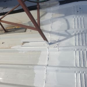 איטום גג עם חומר לבן סביב מתקן מתכת