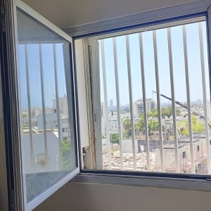 חלון פתוח עם סורגים לבנים