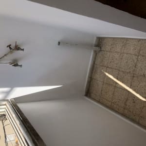 קיר צבוע בלבן עם צינורות חשופים