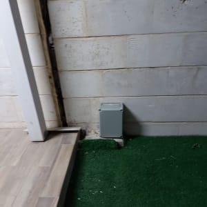 תיבת חשמל אפורה מותקנת על קיר לבנים