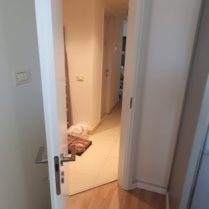 דלת לבנה פתוחה עם ידית מתכת כסופה