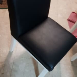 כיסא מרופד שחור עם רגליים לבנות