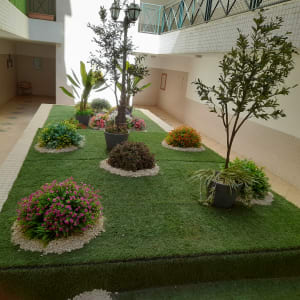 עצים ופרחים בעציצים על דשא מלאכותי