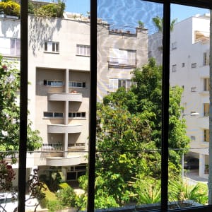 חלון אלומיניום עם נוף לבניינים ועצים