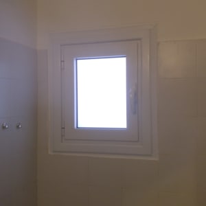 חלון אלומיניום עם מסגרת לבנה וקיר אריחים