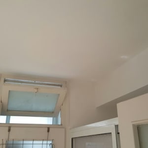 תקרה וקיר צבועים בלבן עם חלון פתוח