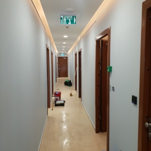 מסדרון עם דלי כחול וכלי צביעה על הרצפה