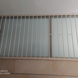 סורגים לבנים על חלון זכוכית חלבית