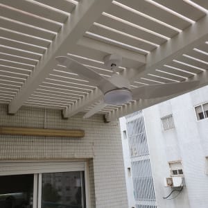 מאוורר תקרה לבן מותקן על פרגולה מעץ