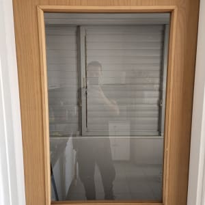 זכוכית בדלת עץ עם השתקפות אדם