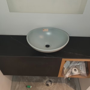 שיש שחור עם כיור עגול בחדר אמבטיה