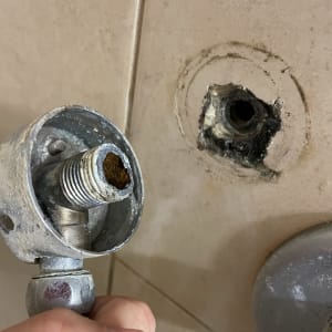 חיבור צינור מתכת עם חלודה בקיר