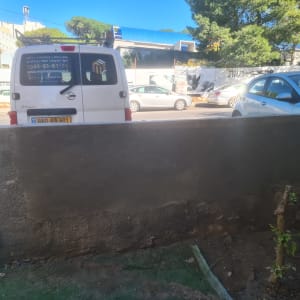 קיר בטון עם תיקוני טיח, רכב עבודה ברקע