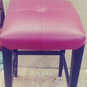 שרפרף מרופד באדום עם רגליים שחורות