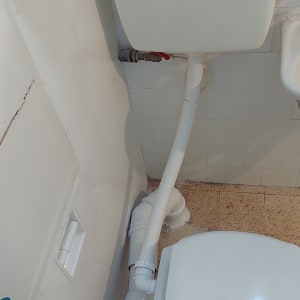 אסלה עם צינור ניקוז ומיכל הדחה