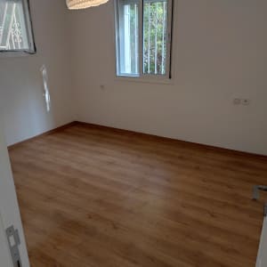 חדר ריק עם רצפת עץ וקירות לבנים