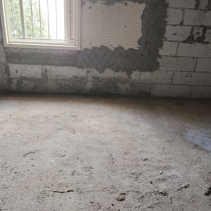 קיר בטון עם חלון וסימני טיח על הקיר