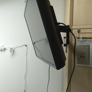 מסך טלוויזיה מותקן על קיר עם זרוע מתכווננת