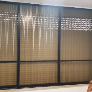 חלון זכוכית עם תריסים סגורים ומסגרת שחורה